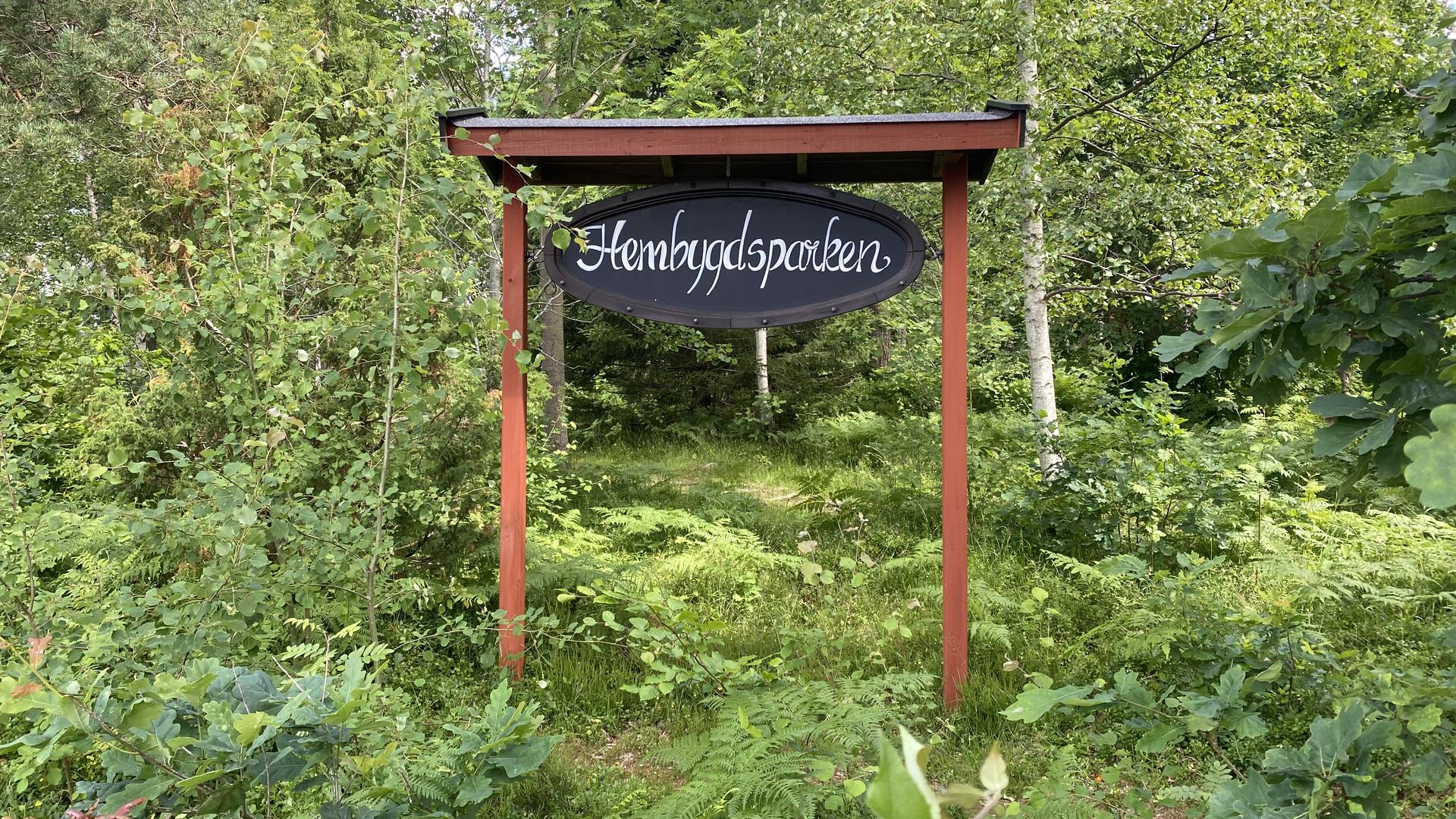 Träskylt Hembygdspark, i grönska